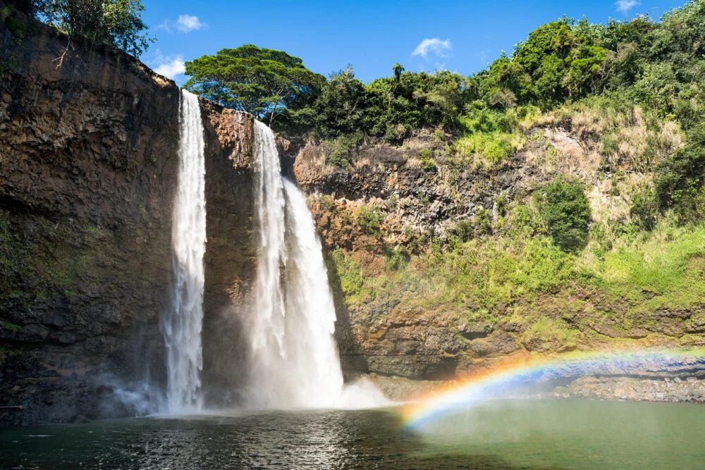 A rainbow rises from the mist at Kauai's Wailua Falls which consists of three dramatic parallel falls. This is one of Hawaii's most beautiful waterfalls