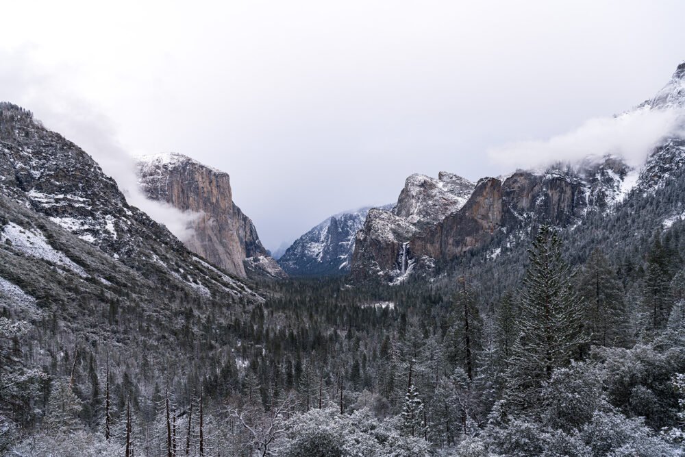 Yosemite Valley after a winter storm highlighting the beauty of nature in dramatic mountains, frozen waterfalls and forests dusted in snow