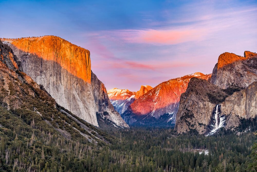 A cold winter Sunset highlights Firefall on El Capitan as the rest of Yosemite Valley's forests, mountains, and waterfalls fall into night's darkness