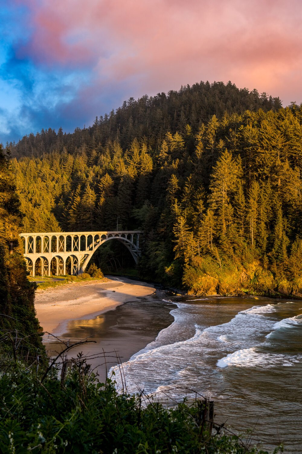 Oregon Coast Highway crosses the Cape Creek Bridge at Heceta Lighthouse Beach at sunset