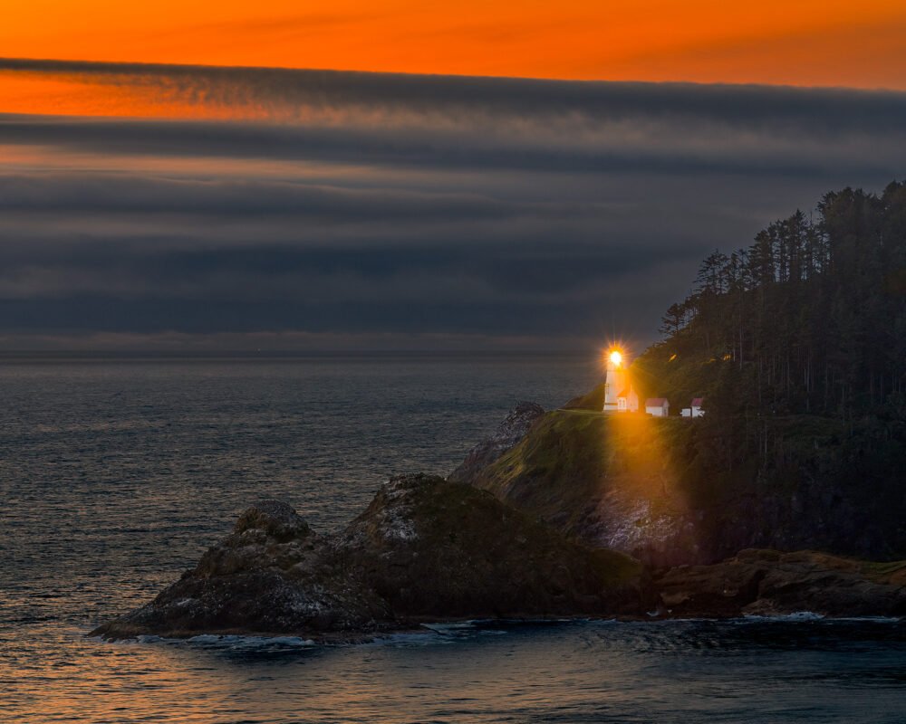 Perched on an Oregon Coast sea cliff, the historic Heceta Head Lighthouse overlooks the Oregon Coast at sunset