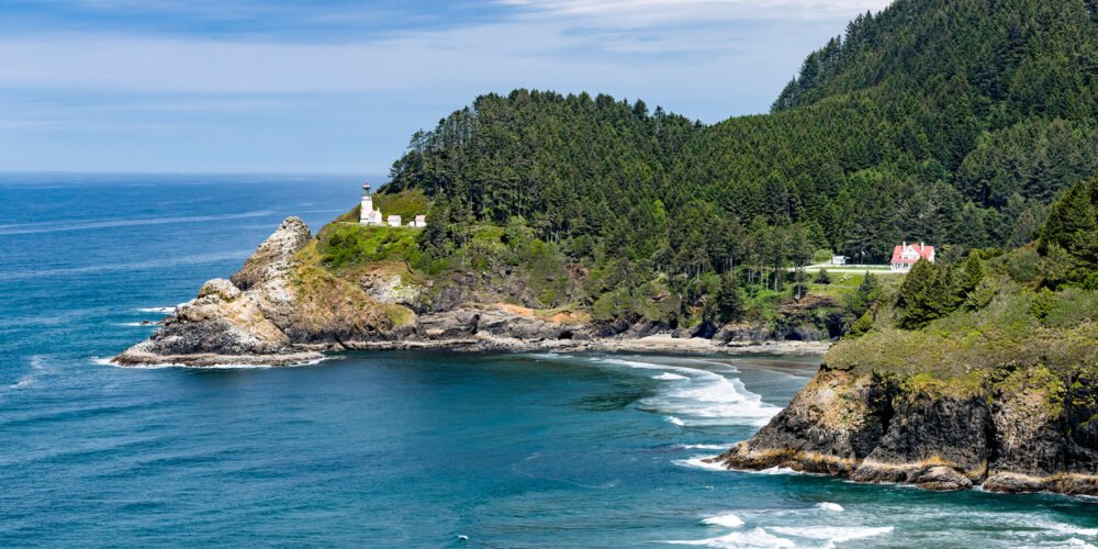 The historic Heceta Head Lighthouse perched on an Oregon Coast sea cliff overlooking Cape Cove and the Oregon Coast
