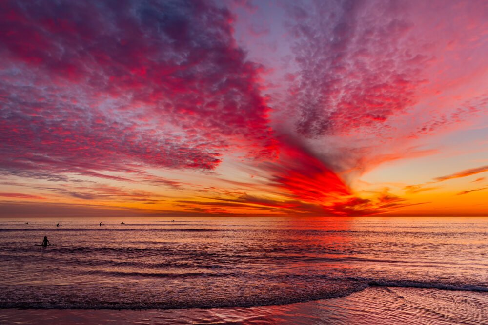 Watching a brilliant and shimmering sunset along the California coast while surfing
