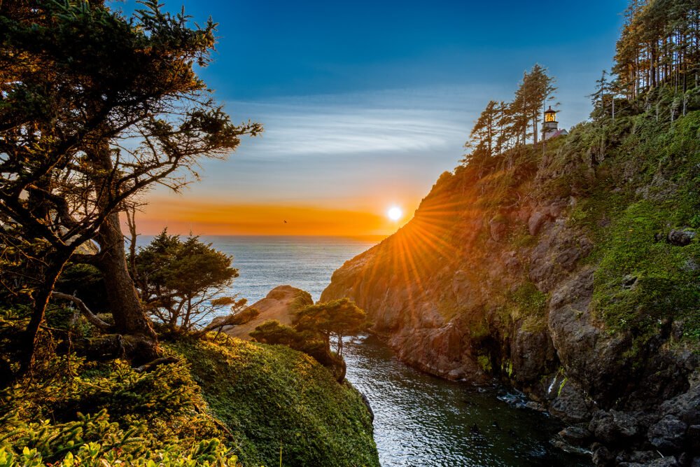 Heceta Head Lighthouse perched on the Oregon Coast sea cliff overlooking the Oregon Coast and a beautiful sunset