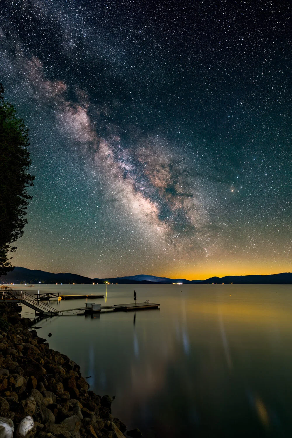 The Milky Way rises above and reflects in Lake Almanor in California. Beautifull Lake Almanor, is surrounded by forests and mountains