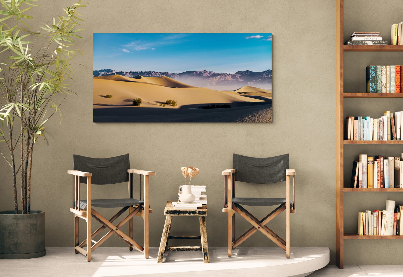 A dramatic scene capturing the sun rising over the Mesquite Flats sand dunes of Death Valley displayed in a cozy living area with folding chairs.