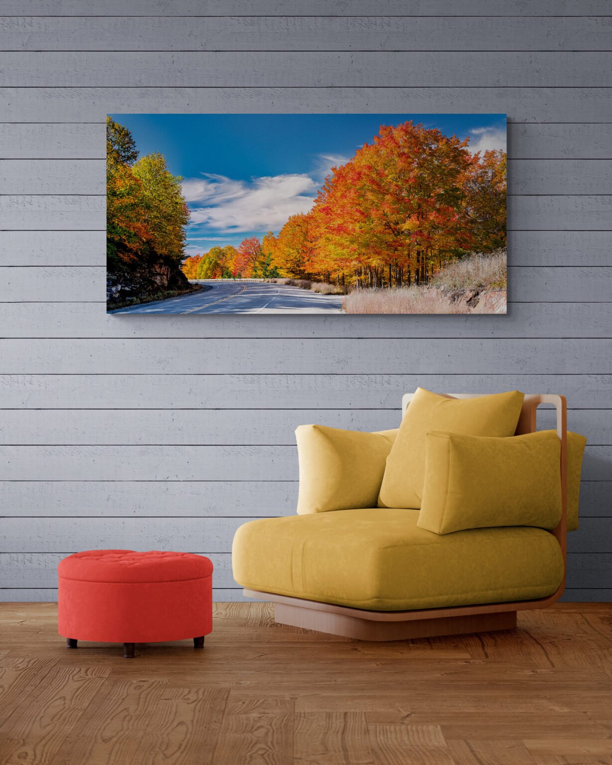 Brightly colored trees filled with the golden, orange and red leaves of Autumn Fall Colors come to the Rangeley Lake area of Maine displayed in a room with fancy armchair and foot stool