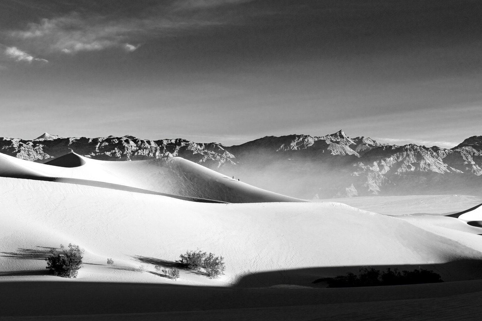 A black and white image of sunrise illuminating the sand dunes of Death Valley